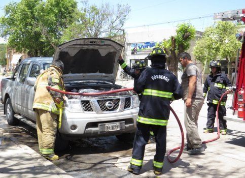 Bomberos realizando trabajos para enfr&iacute;ar el motor de la camioneta.